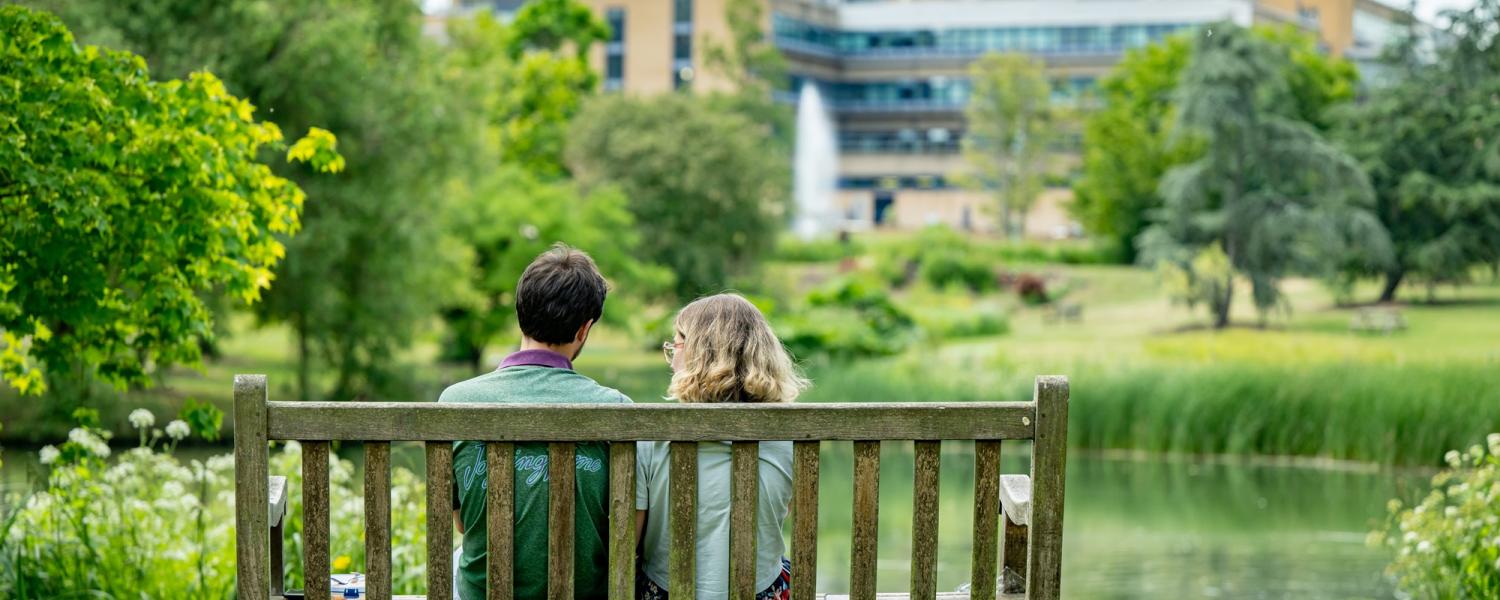 Two students sitting on a bench by the Lake