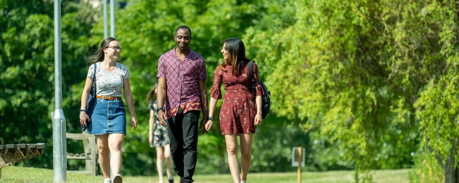 Three students walking on the pathway by the Lake