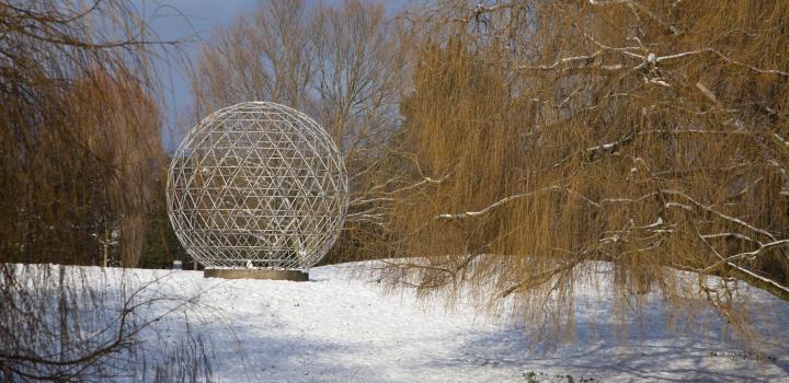 A picture of the globe by the lake, with the ground covered in snow
