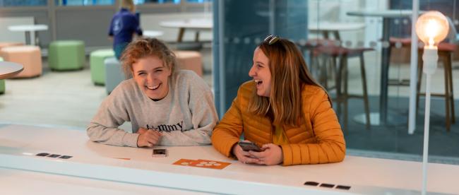 Two students laugh in MySurrey Hive