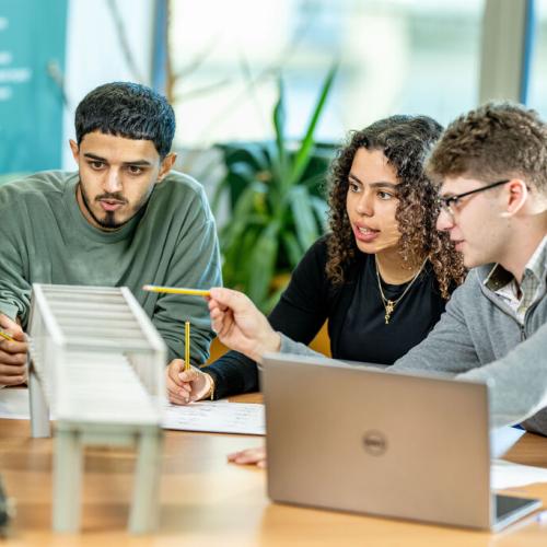 Three students work together on a project